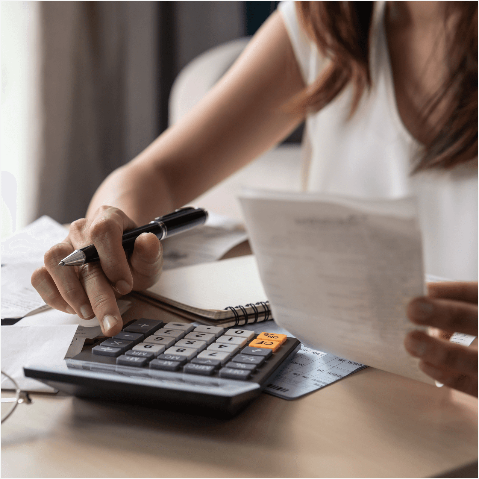 A person using a calculator to tally receipts