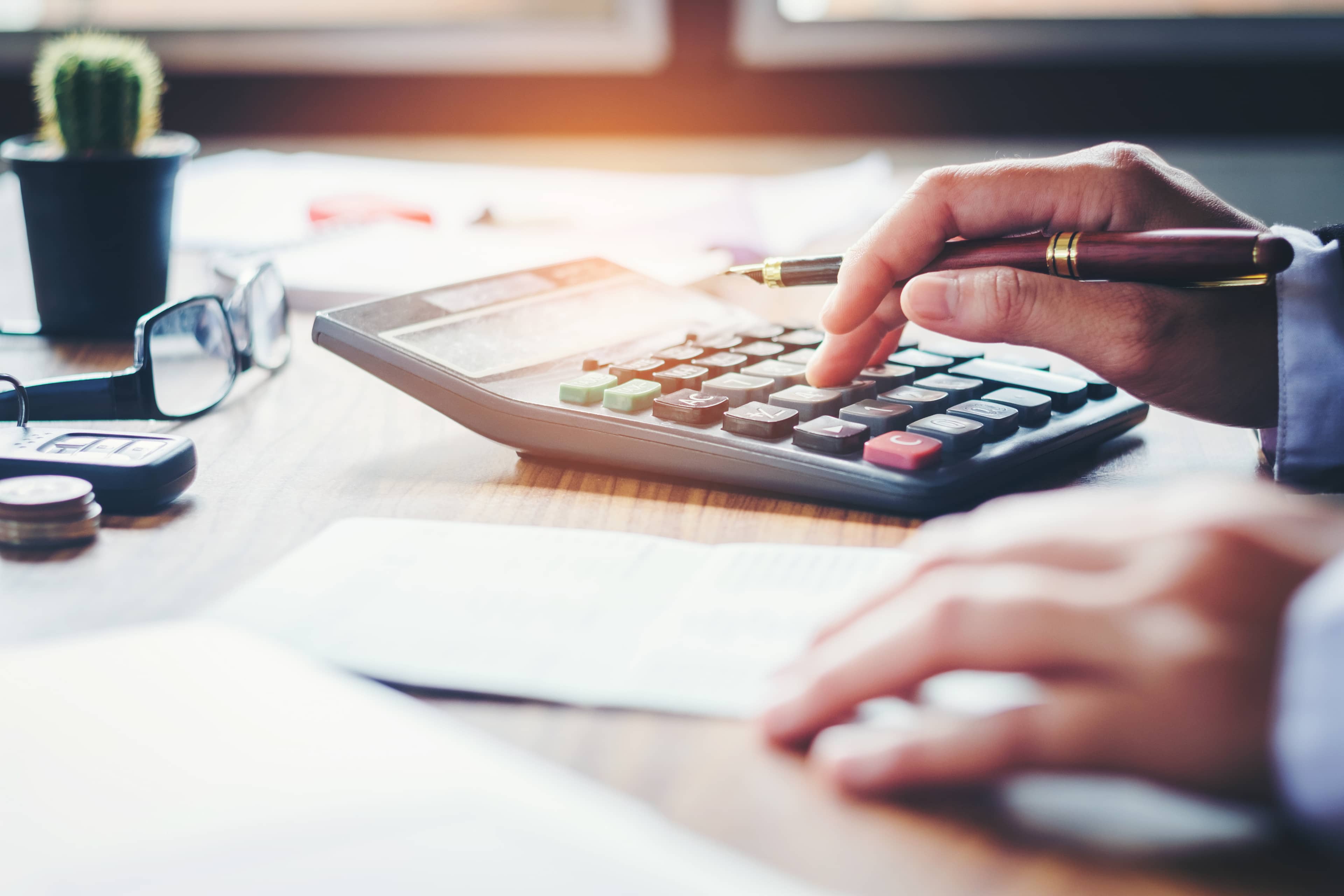 A person using a calculator at a desk